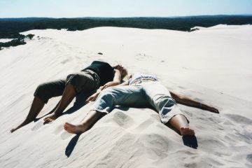 2 Frauen liegen auf Sandduene